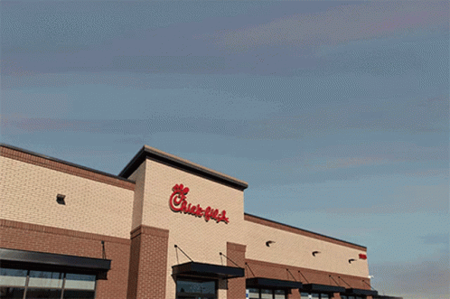The Outside Of A Chick-Fil-A Restaurant With A Blue Sky Behind It GIF