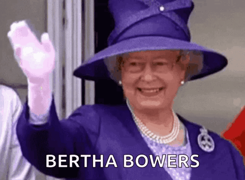 The Queen Is Wearing A Purple Hat And Gloves And Waving At The Camera . GIF