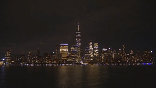 The Skyline Of New York City At Night With One World Trade Center In The Foreground GIF