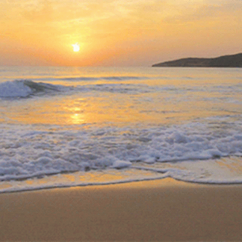 The Sun Is Setting Over The Ocean And The Waves Are Coming In GIF