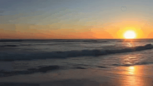 The Sun Is Setting Over The Ocean With A Heart Shaped Bubble In The Sky GIF