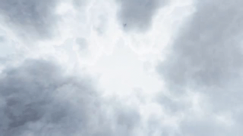 The Sun Is Shining Through The Clouds In A Cloudy Sky . GIF