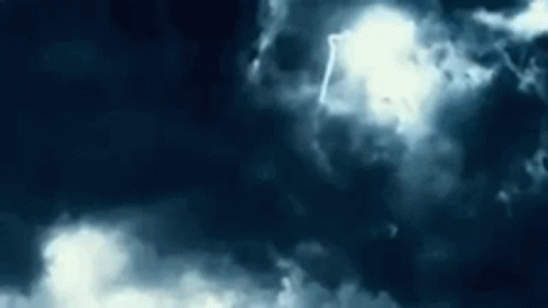 The Sun Is Shining Through The Clouds In A Dark Sky . GIF