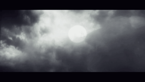 The Sun Is Shining Through The Clouds In The Sky In A Black And White Photo . GIF
