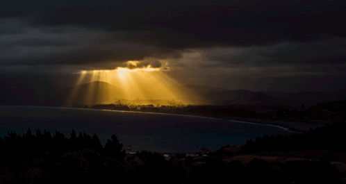 The Sun Is Shining Through The Clouds Over A Lake GIF