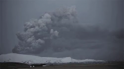 The Sun Is Shining Through The Clouds Over A Snow Covered Mountain . GIF