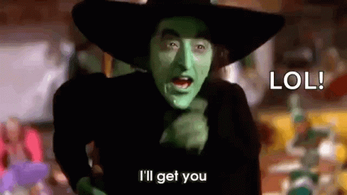 The Wicked Witch From The Wizard Of Oz Is Wearing A Black Hat And Green Paint On Her Face . GIF