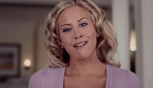 The Woman Is Wearing A Purple Sweater And Smiling . GIF