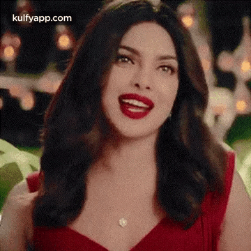 The Woman Is Wearing A Red Dress And Red Lipstick And Smiling . GIF