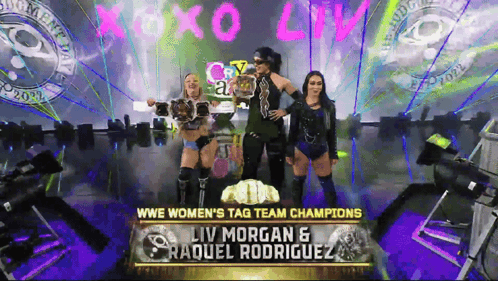 The Women 'S Tag Team Champions Liv Morgan And Raquel Rodriguez Are On A Stage GIF