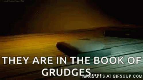 They Are In The Book Of Grudge Written On A Wooden Surface . GIF