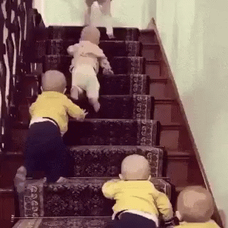 Three Babies Are Climbing Up A Set Of Stairs Together . GIF