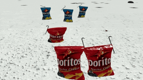 three bags of doritos nacho cheese are sitting on a snowy beach