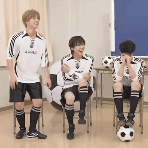 three boys wearing soccer uniforms with a team on the front