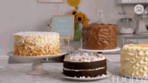 Three Cakes Are Sitting On A Table In Front Of A Sign That Says " Share Every Moment " GIF