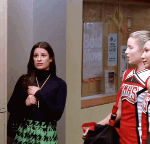 Three Cheerleaders in Front of Bulletin Board With Bold Move Poster