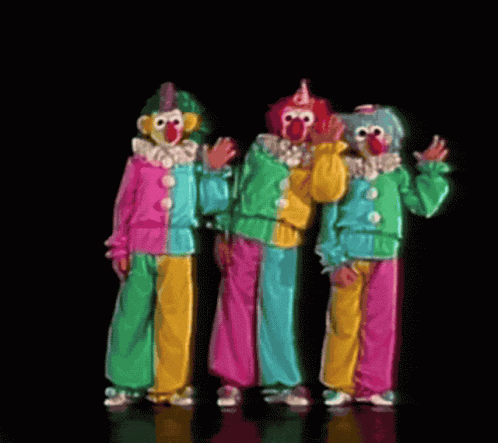 Three Clowns Are Standing Next To Each Other And Waving At The Camera GIF