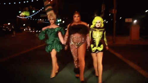 Three Drag Queens Walking at Night Holding Hands