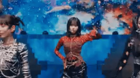Three Girls Are Dancing On A Stage In Front Of A Blue Background . GIF