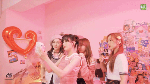 Three Girls Taking Selfie In Front Of Ali Magazine Wall GIF