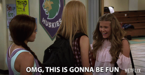 Three Girls Talking In Front Of Huskies Banner GIF