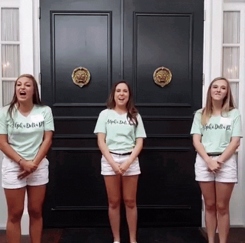 Three Girls Wearing Shirts That Say Alpha Delta Pi Stand In Front Of A Black Door GIF