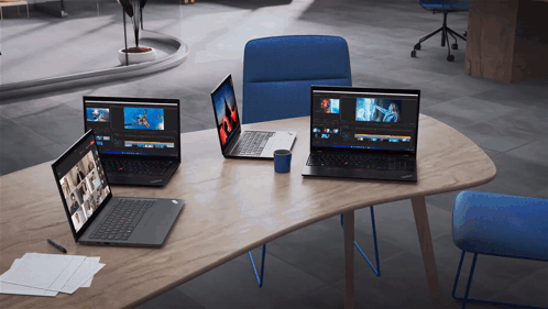 Three Laptops on Wooden Table One Open