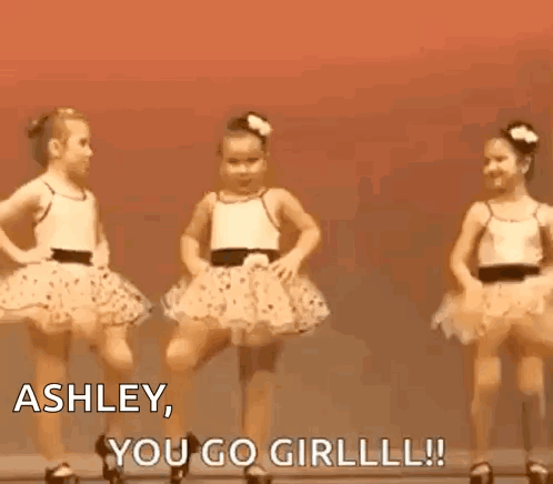 three little girls are dancing on a stage and one of them is saying `` ashley , you go girl ! ''