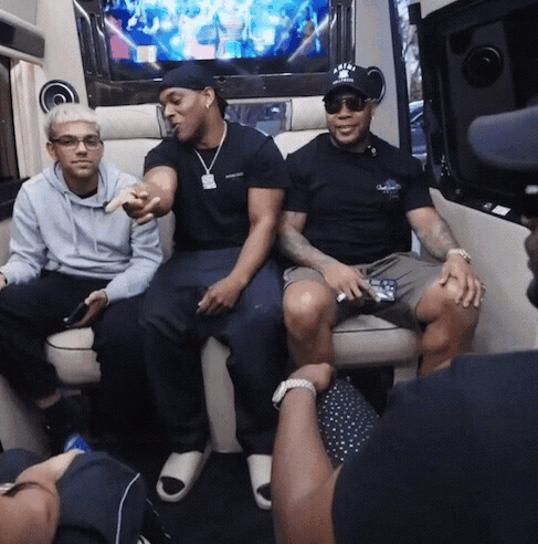 three men are sitting in a van and one of them is wearing a hat that says a & a on it