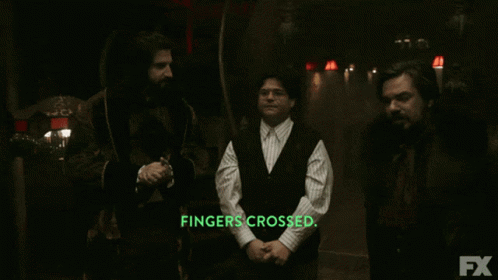 Three Men Are Standing In A Dark Room With The Words Fingers Crossed In Green Letters GIF