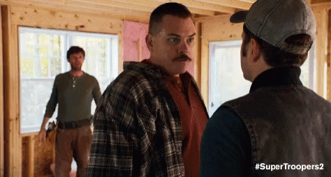 Three Men Are Standing In A Room Talking To Each Other . GIF