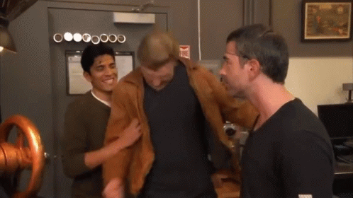 Three Men Are Standing In Front Of A Door That Has A Fire Extinguisher Sign On It GIF
