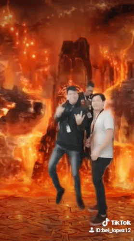 three men are standing in front of a fire background .