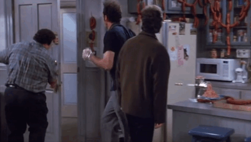 three men are standing in front of a refrigerator that has a sticker on it that says ' a ' on it