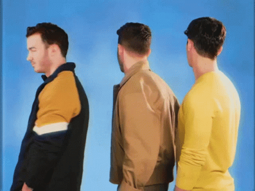 Three Men Are Standing Next To Each Other And One Is Wearing A Yellow Sweater GIF