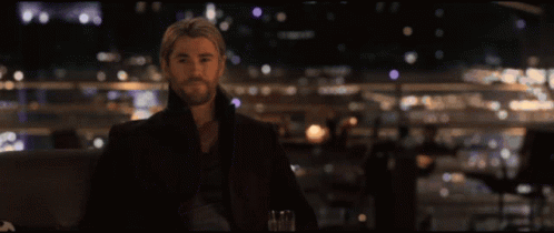Three Men Are Standing Next To Each Other And One Of Them Is Holding A Bottle GIF