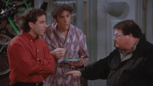 Three Men Are Standing Next To Each Other In A Room And One Of Them Is Holding A Frisbee GIF