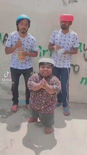 Three Men Are Standing Next To Each Other In Front Of A Wall . One Of The Men Is Wearing A Red Hat . GIF