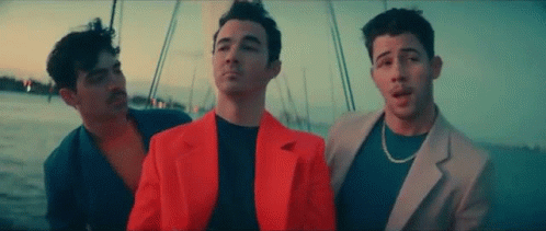 Three Men Are Standing Next To Each Other On A Boat In The Ocean . GIF
