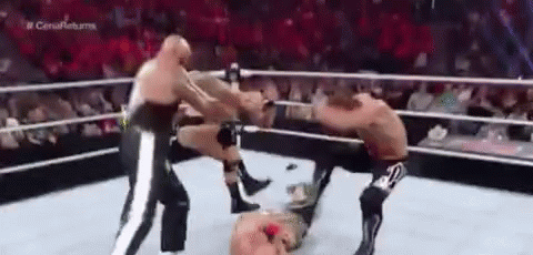 Three Men Are Wrestling In A Ring With A Referee . GIF