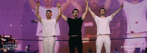 Three Men Arms Up Stage Happiness Continues