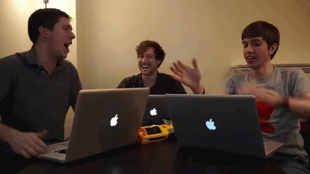 Three Men At Table With Two Apple Laptops GIF