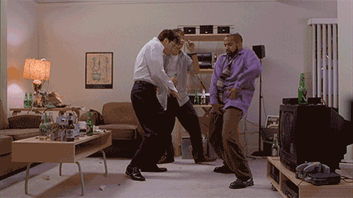 Three Men Dancing in Living Room With Egyptian Poster