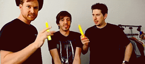 Three Men Holding Yellow Sticks GIF