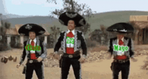 Three Men In Mariachi Costumes Are Dancing In A Desert GIF