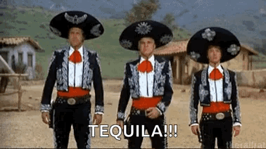 Three Men In Mariachi Costumes Are Standing Next To Each Other In A Row In A Desert . GIF