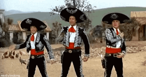 Three Men In Mariachi Costumes Are Standing Next To Each Other In The Desert . GIF