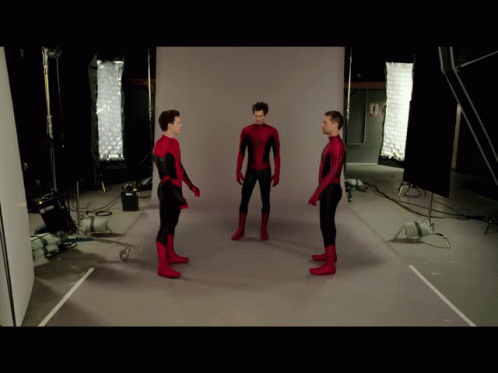 Three Men In Spiderman Costumes Are Standing In Front Of A White Wall GIF