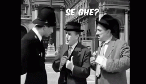 Three Men In Suits And Hats Are Standing Next To Each Other On A Street Talking To Each Other . GIF