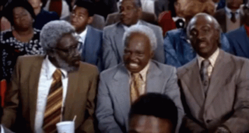 Three Men In Suits And Ties Are Sitting In A Crowd GIF